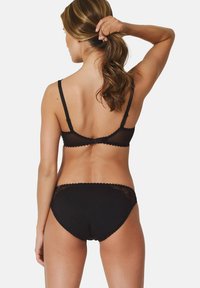 Black lingerie set featuring a sheer bralette with adjustable straps and scalloped edges, paired with black panties with lace accents.