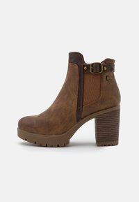 Braune Knöchelstiefel mit strukturiertem Obermaterial, elastischen Seitenpanelen, Schnallen-Detail und hohem, geripptem Absatz. Verstärkte Gummisohle für besseren Halt.