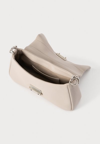 Μπεζ τσάντα χειρός με λεία, υφή με υφή, εσωτερική τσέπη και ασημένιες μεταλλικές λεπτομέρειες. Διαθέτει δομημένο σχεδιασμό και μαλακές άκρες.