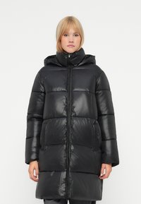 Casaco puffer preto com acabamento brilhante, apresentando uma capuz, fecho de correr completo e seções acolchoadas horizontais. Mangas longas e bolsos laterais visíveis.