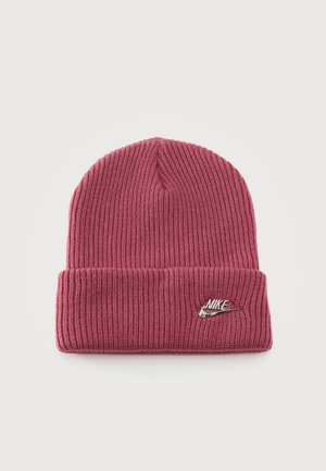Bonnet en maille côtelée rose poudré, avec un revers et un logo Nike argenté, présenté sur un fond clair.