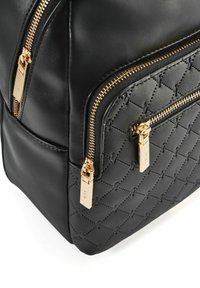 Czarny plecak z sztucznej skóry z pikowanym wzorem, złotymi zamkami błyskawicznymi i podwójnymi przednimi kieszeniami. Charakteryzuje się gładką teksturą i solidną konstrukcją.