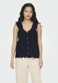 Marineblauw mouwloos topje met een gegolfde zoom, gerimpelde halslijn en oogjes borduursel; heeft knopen aan de voorkant en een relaxed fit.