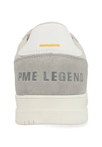 Witte en grijze sneaker met suède en leren materialen, een gestructureerde hak met de opdruk "PME LEGEND" en een gele accent aan de bovenkant.