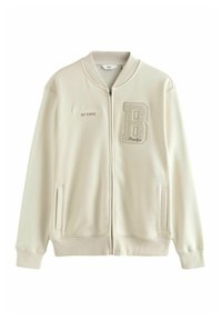 Giacca bomber beige chiaro con zip, polsini a coste, due tasche laterali e ricamo "Williamsburg NY STATE" e logo "B" sul petto.