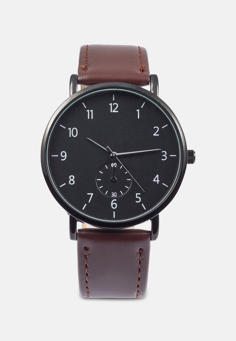 Black analog watch with a round face, white hour markers, sub-dial, and a brown leather strap featuring stitching details.