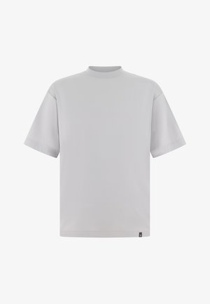 Camiseta de manga corta color gris claro con cuello alto, ajuste holgado y textura suave. Cuenta con una pequeña etiqueta de la marca cerca del dobladillo.