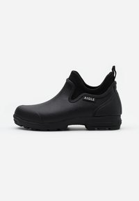 Black ankle boot made of rubber with a textured finish, pull tab, and chunky rubber sole, featuring a logo on the side.