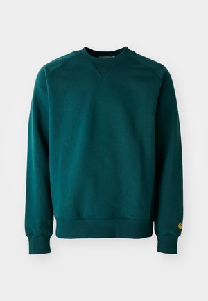 Ciemnoniebieski sweter z dekoltem w kształcie litery V, ściągaczami przy mankietach i u dołu. Wykonany z miękkiego materiału, z małym logo na lewym rękawie.