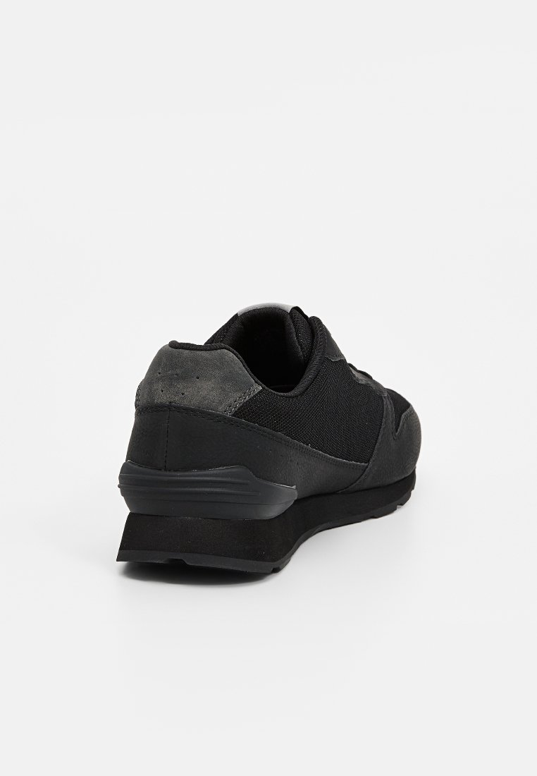 Baskets noires avec un dessus en mesh et des accents en cuir, design élégant, col rembourré et semelle texturée pour une meilleure adhérence.