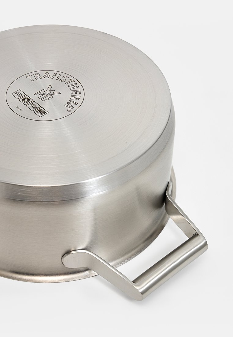 Czyściutki garnek ze stali nierdzewnej z matowym wykończeniem, okrągły kształt i metalowy uchwyt. Posiada okrągłe logo na pokrywce. Gładka faktura.