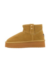 Stivale alla caviglia in suede color sabbia con punta rotonda e una fascia in velcro con due stelle decorative. Suola in gomma marrone spessa con superficie testurizzata.