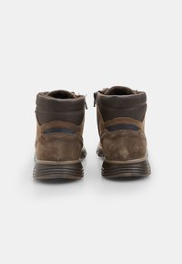 Barna velúr bokacsizmák sötétbarna bőr gallérral, oldalsó cipzárral és texturált gumitalppal; díszvarrásos részletek jellemzik.