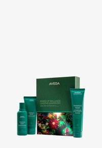 Ett Aveda presentbox i mörkgrön färg, som innehåller tre botaniska reparationsprodukter: schampo, balsam och leave-in behandling, med färgglada blommönster.