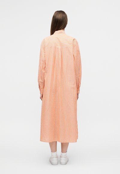 Μακρύ φόρεμα πορτοκαλί και λευκές ρίγες με γιακά με κουμπιά, μακριά μανίκια και φαρδιά γραμμή, που φτάνει μέχρι τη μέση της γάμπας. Ομαλή υφή υφάσματος.