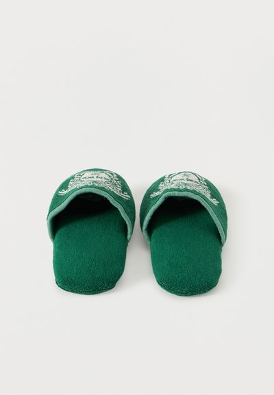 Πράσινες ανοιχτές παντόφλες με λευκό κεντητό σχέδιο στην κορυφή, κατασκευασμένες από μαλακό ύφασμα, τοποθετημένες πλάι πλάι σε απλό φόντο.