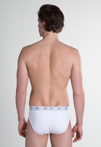 Witte katoenen slipjes met een grijze tailleband met het "CR7"-logo, eenvoudig ontwerp, nauwsluitende pasvorm en zachte textuur.