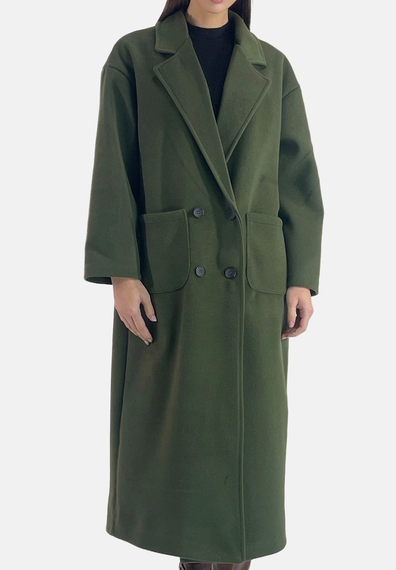 Cappotto lungo verde oliva realizzato in tessuto morbido. Presenta un colletto con rever, bottoni doppiopetto e due tasche frontali.