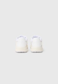 Sapatos brancos com cabedal em couro suave, detalhes texturizados em cores claras e sola almofadada com uma base de borracha transparente.