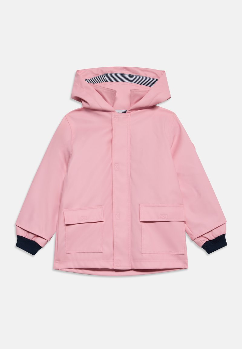 Imperméable rose pour enfant avec capuche, poches avant à rabat et poignets élastiques noirs, doublé de rayures bleu marine et blanc à l’intérieur de la capuche.