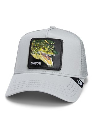 Gorra gris con un panel frontal sólido, que presenta un parche de cocodrilo bordado. Parte trasera de malla, visera curvada y logo de la marca en el lado.