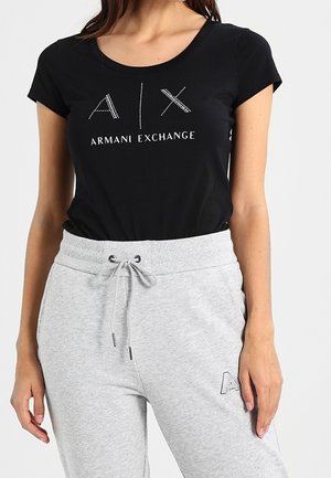 T-shirt noir à manches courtes avec un logo orné de cristaux "A|X ARMANI EXCHANGE", associé à un pantalon de survêtement gris clair avec taille à cordon.