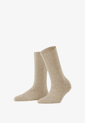 Beige ribbed socks made from a soft material; mid-calf length with a textured design and a smooth toe area. Standard pair.