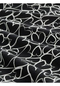 Zwarte stof met een wit hartpatroon, met een gladde textuur en een zachte val. De harten variëren in grootte en zijn verspreid over het materiaal.