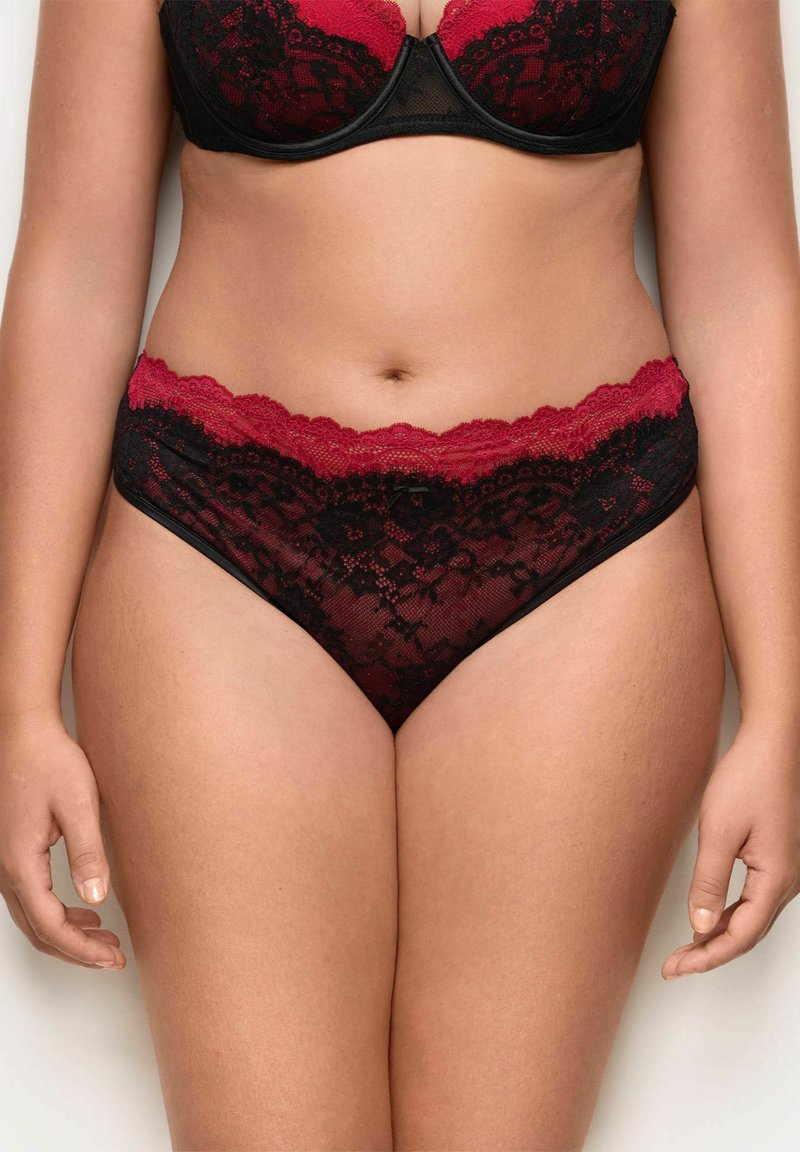 Set di lingerie in pizzo nero con rifiniture rosse. Il reggiseno ha supporto con ferretto e dettagli decorativi in pizzo, mentre le mutandine presentano un design in pizzo simile.
