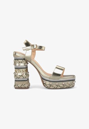Gold metallic high-heeled sandal with a thick, textured block heel featuring braided and beaded details. Ankle strap with buckle closure.