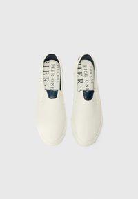 Fehér slip-on cipők texturált felülettel és sötétkék akcentussal az elején. A belső részen a "PIER ONE" feliratozás található.
