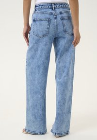 Ljust blå denimbyxor med vida ben och hög midja, fem fickor och en urtvättad textur. Avslutade med en sydd fåll och bälteshällor.