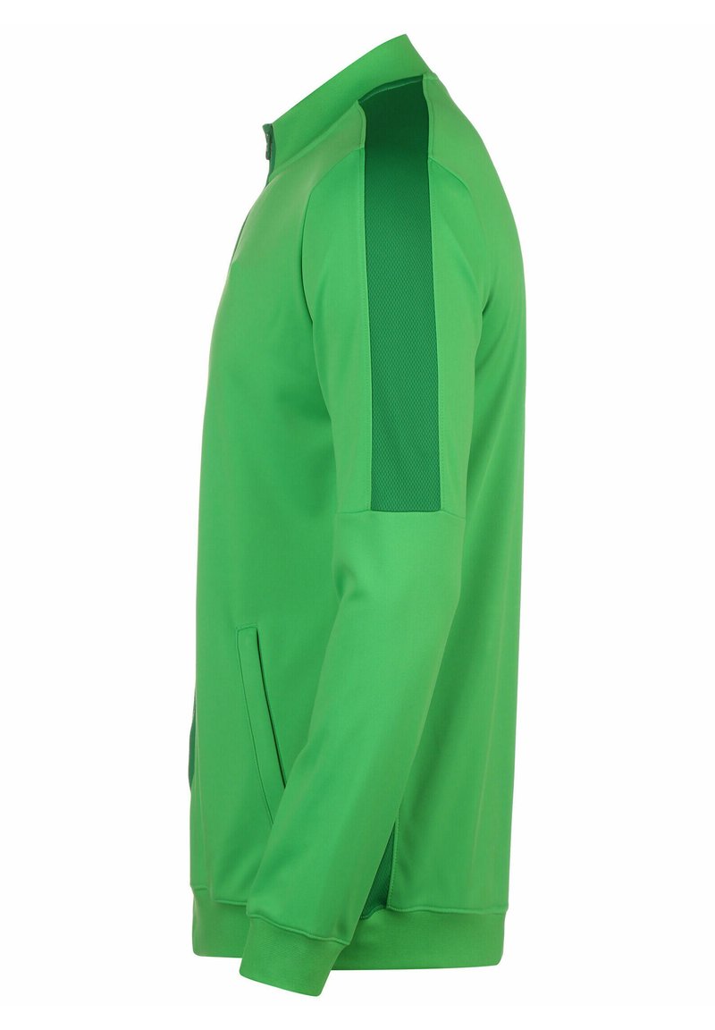 Chaqueta deportiva verde con un alto cuello, bolsillos laterales y paneles texturizados en los hombros. Tejido suave con detalles de color contrastante.