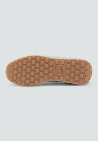 Sole of light blue sneaker with hexagonal rubber studs and "PATRICK" logo embossed on the brown outsole against a gray background.