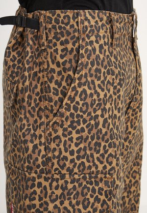 Spodnie cargo w lamparta w odcieniach brązu i czerni. Posiadają wyraźne boczne kieszenie oraz pasek w talii, z widocznymi detalami ściegów.
