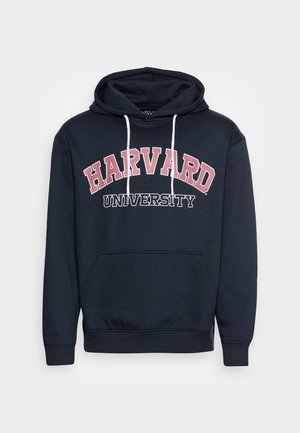 Granatowa bluza z kapturem z białymi sznurkami i kieszenią z przodu, z napisem "HARVARD UNIVERSITY" w kolorze czerwonym i białym na piersi.