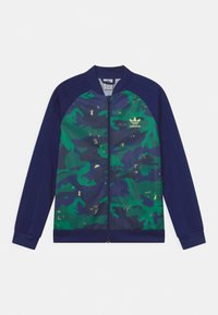 Marinblå och grön kamouflagemönstrad zip-jacka med gyllene detaljer, med ribbade ärmslut och en enfärgad baksida, tillverkad av ett mjukt och lätt tyg.