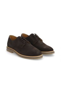 Chaussures en daim marron foncé avec lacets, dotées d'un bout arrondi et d'une semelle en caoutchouc tan contrastante. Des surpiqûres autour de la semelle ajoutent de la texture.