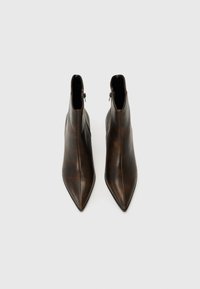 Bottines en cuir marron, à bout pointu et au design épuré, avec une fermeture éclair sur le côté et une finition lisse.