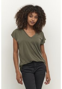 T-shirt vert olive à col en V avec manches courtes, en tissu doux, coupe décontractée, porté avec un jean noir, design minimaliste, texture lisse.