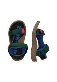 Blauwe en zwarte sandalen met groene verstelbare banden en rode accenten. Dikke bruine buitenzool met gestructureerde grip en een gepatternde voetbed.