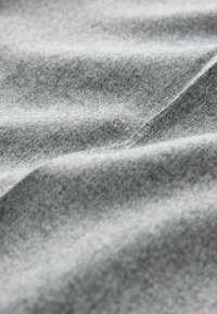 Gray fabric with a soft texture, displaying subtle variations in shade and a fluid, draped appearance. Stretchable and smooth finish.