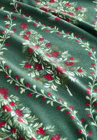 Stof de fleece verde cu un model floral, având fructe roșii și flori, accentuate de frunze și ramuri de un verde deschis.