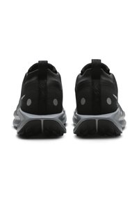 Black athletic shoes with a mesh upper, two reflective dots for visibility, and a textured gray outsole. Designed for comfort and stability.