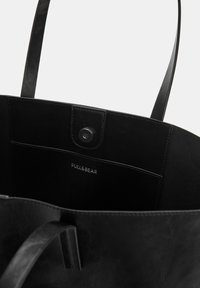 Borsa a spalla nera realizzata in materiale sintetico texturizzato. Presenta una chiusura a pressione, un interno con marchio e due manici resistenti.