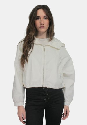 Giacca corta bianca e leggera con cappuccio, chiusura con zip e polsini elasticizzati. Caratterizzata da una texture liscia e da un design semplice.