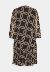 Robe noire avec un motif géométrique de chaînes en or et crème. Ourlet à volants et manches trois-quarts en tissu léger et transparent.