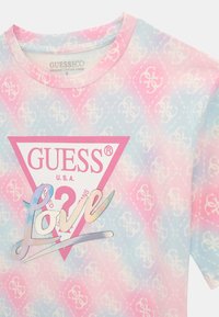T-shirt i bomuld med et gradientmønster i pink og blå, med et hvidt trekantet logo og iriserende "Love" tekst i midten.
