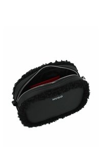 Borsa rettangolare nera con rifiniture in peluche nero, caratterizzata da un materiale esterno liscio, una chiusura con zip e un interno rosso a contrasto.