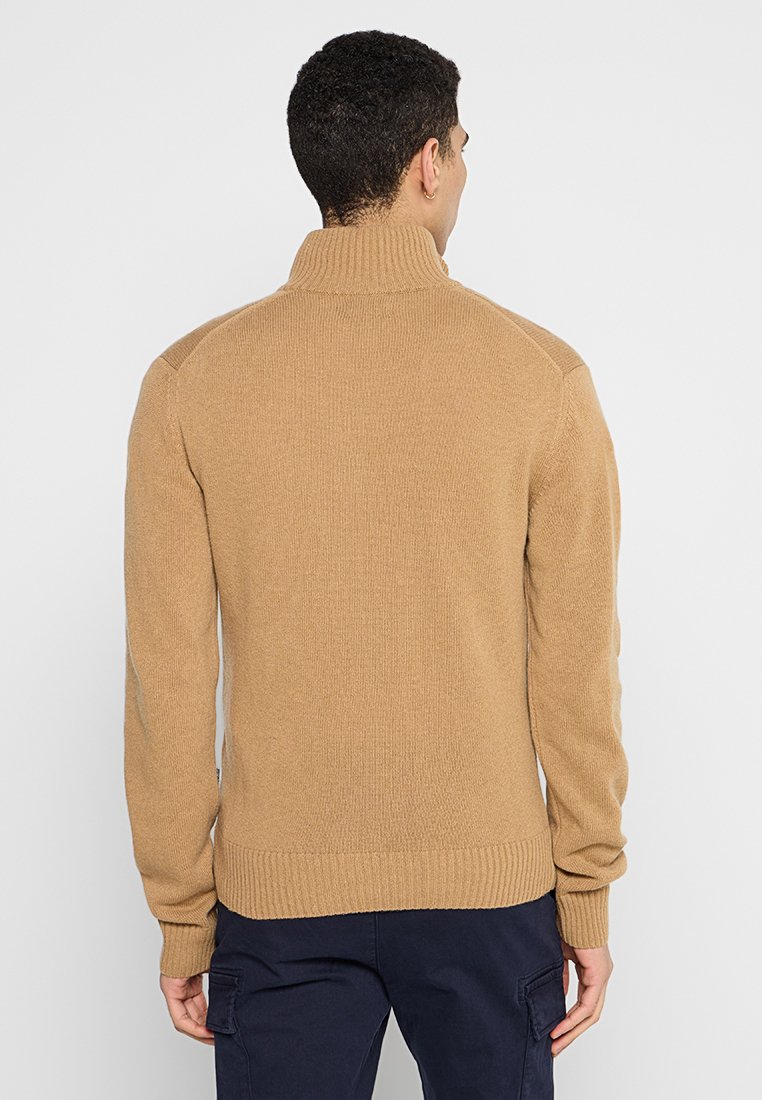 Bruine gebreide trui met een hoge kraag, geribde manchetten en onderrand. Heeft een gestructureerd patroon en een getailleerd ontwerp, ideaal voor een comfortabele pasvorm.